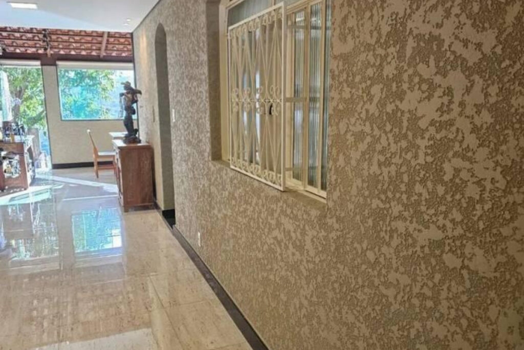 Detalhe técnico aproximado de amostra de revestimento de pedras naturais granilha aplicado em muro residencial na Mooca.