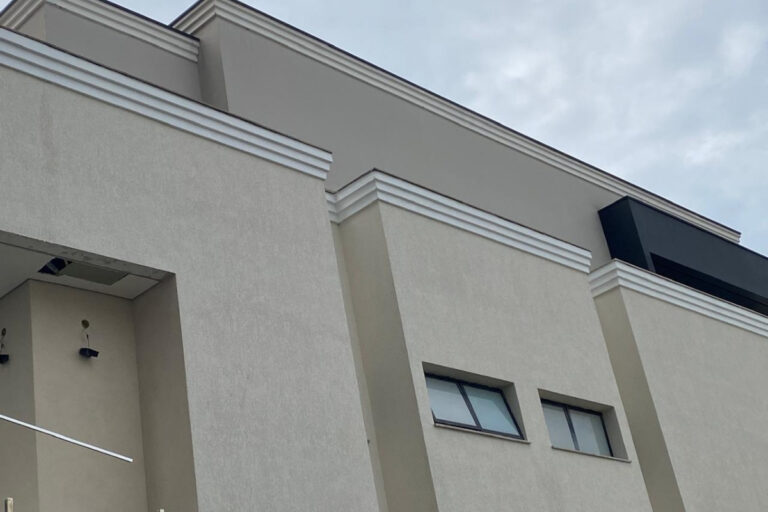 Detalhe técnico de revestimento de pedras naturais granilha aplicado em fachada de sobrado de alto padrão no bairro de Moema.