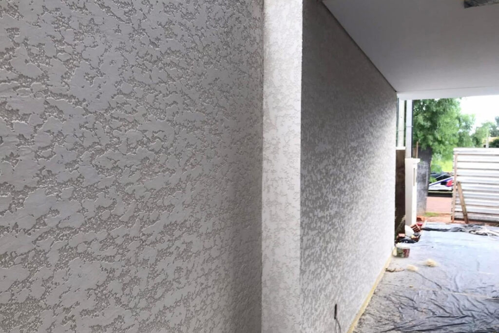 Parede de imóvel residencial em Heliópolis com acabamento em textura projetada e proteção de resina acrílica da Big Texturas.