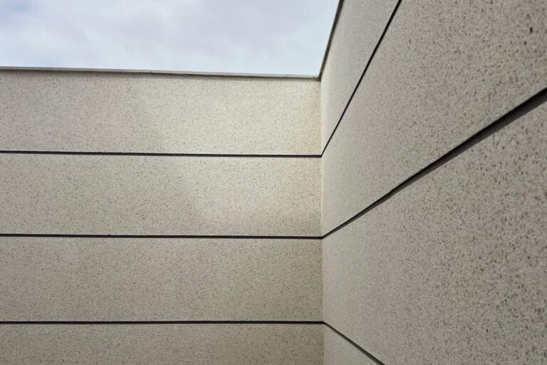 Detalhe técnico de aplicação de textura granilha em parede externa de sobrado de alto padrão no bairro do Parque São Lucas.